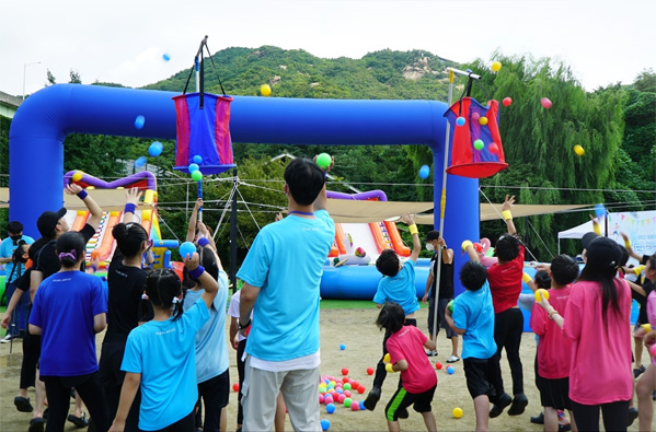 Children and adults playing a game of catch together